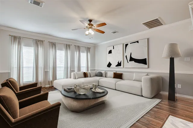an empty room with wooden floor fan and windows