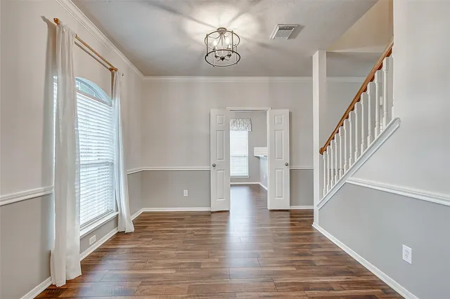 a view of a dining room with furniture a chandelier and wooden floor