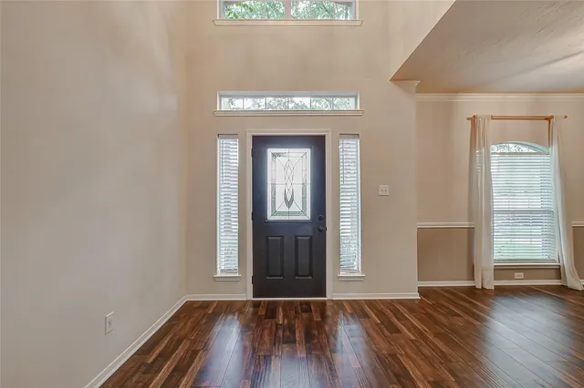 a view of a hallway with wooden floor and a chandelier