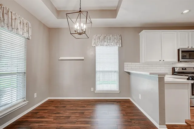 a kitchen with granite countertop white cabinets and stainless steel appliances