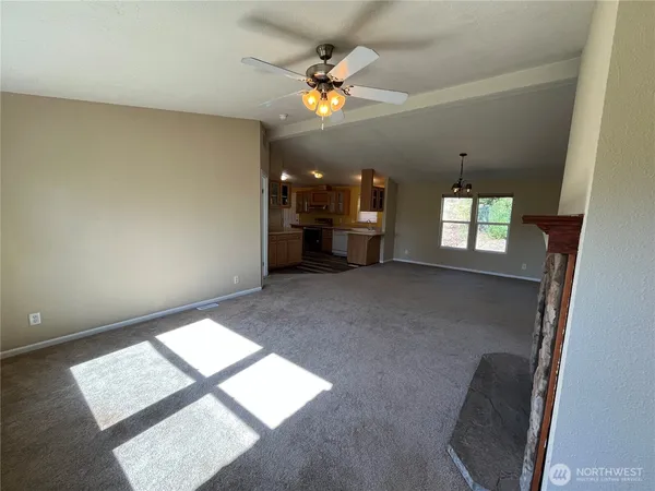 a view of empty room with floor to ceiling window and fireplace