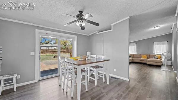 a view of a livingroom with furniture a ceiling fan and wooden floor