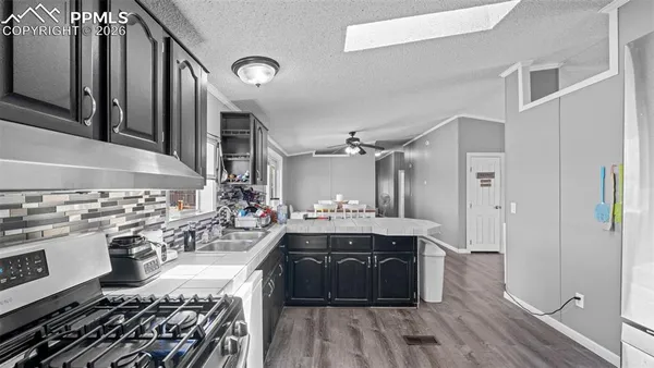 a large kitchen with a stove and wooden floor