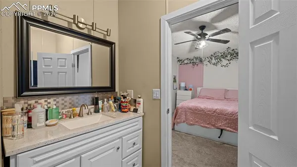 a en suite bathroom with a granite countertop sink and a mirror