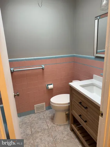 a bathroom with a sink a toilet and a mirror