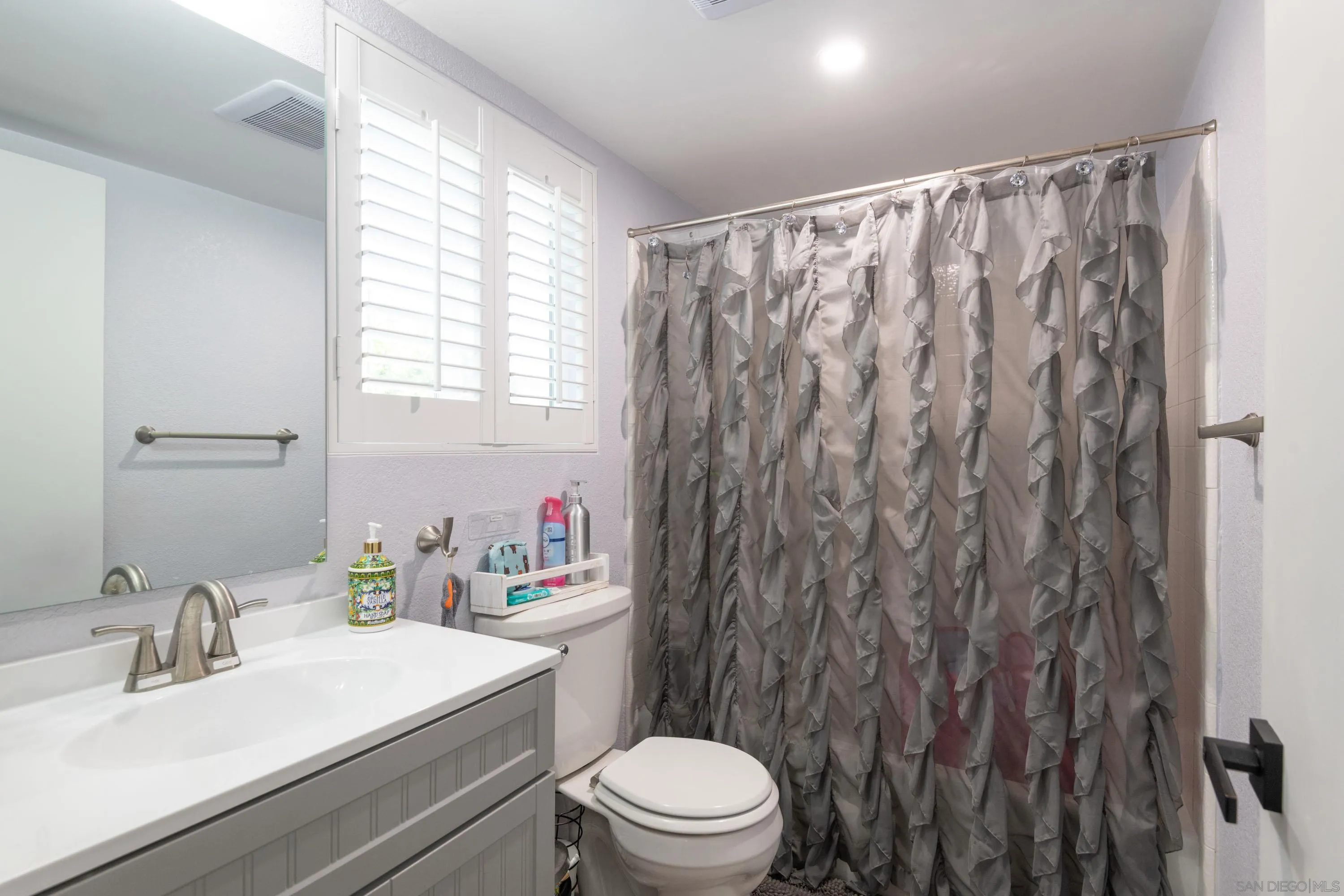 7585 Eads Avenue, Unit A La Jolla, CA 92037 - Photo 18 of 33 a bathroom with a sink a toilet and a mirror