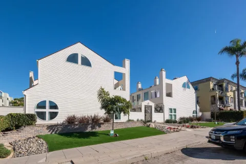 a view of a white building among the street with parked cars