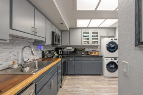 a kitchen with a sink a stove top oven and refrigerator