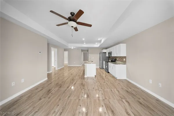 a view of empty room with wooden floor and ceiling fan