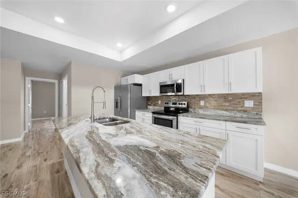 a kitchen with sink a microwave and cabinets