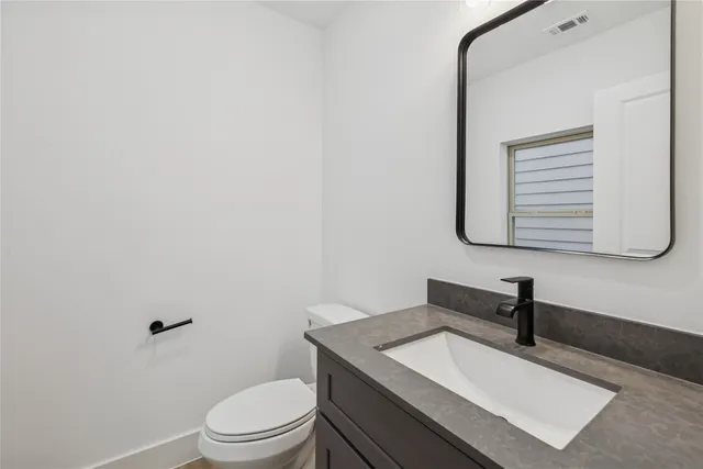a bathroom with a sink a toilet and mirror