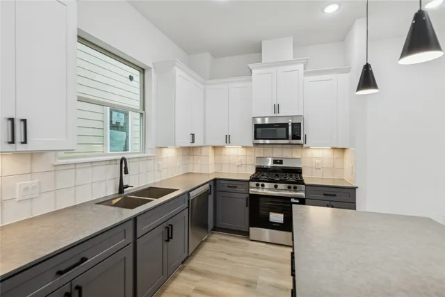 a kitchen with granite countertop a sink and steel appliances