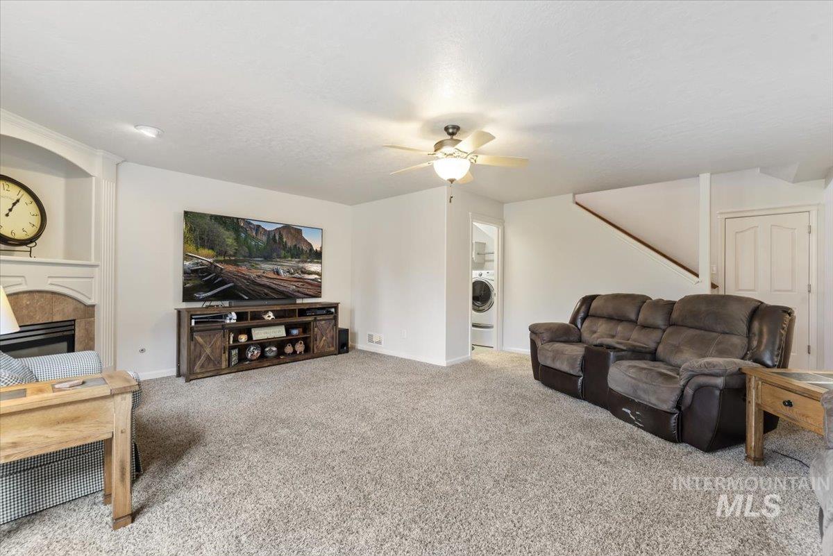 4167 North Arches Way Meridian, ID 83646 - Photo 6 of 36 Carpeted living area with a fireplace, ceiling fan, and washer / clothes dryer