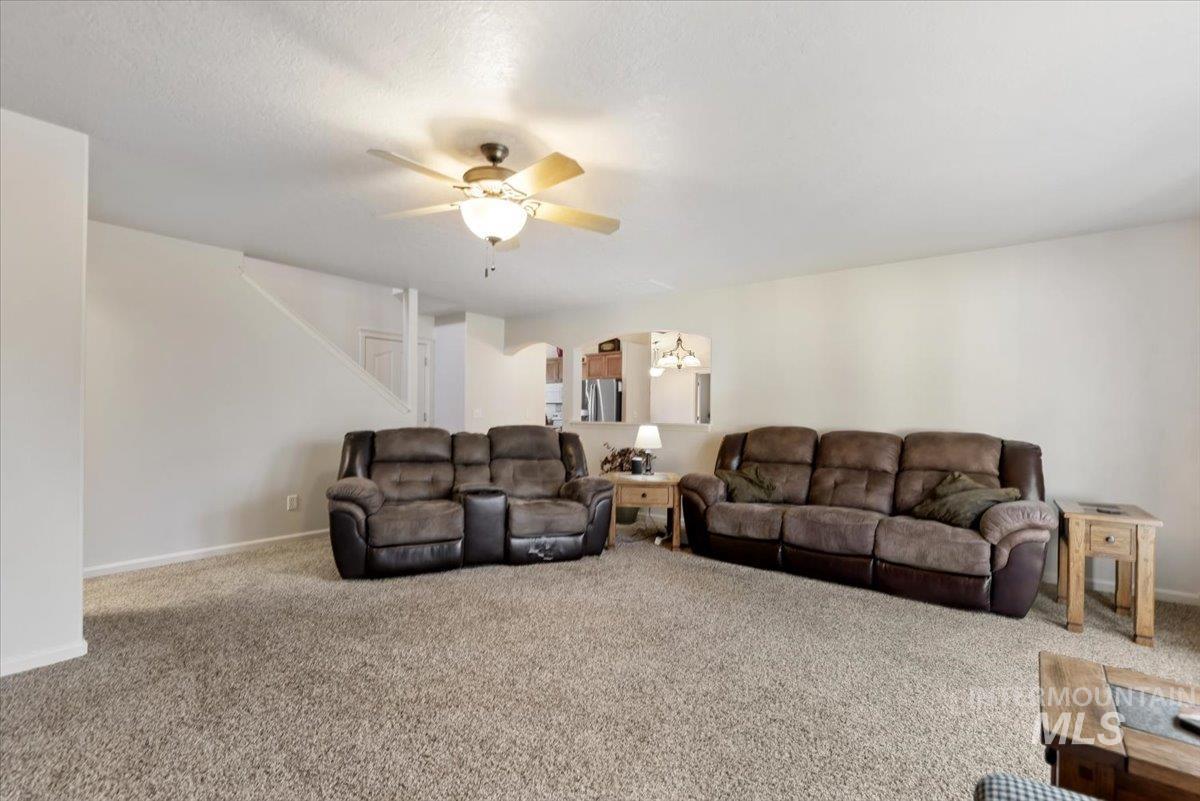 4167 North Arches Way Meridian, ID 83646 - Photo 7 of 36 Carpeted living area with arched walkways and a ceiling fan