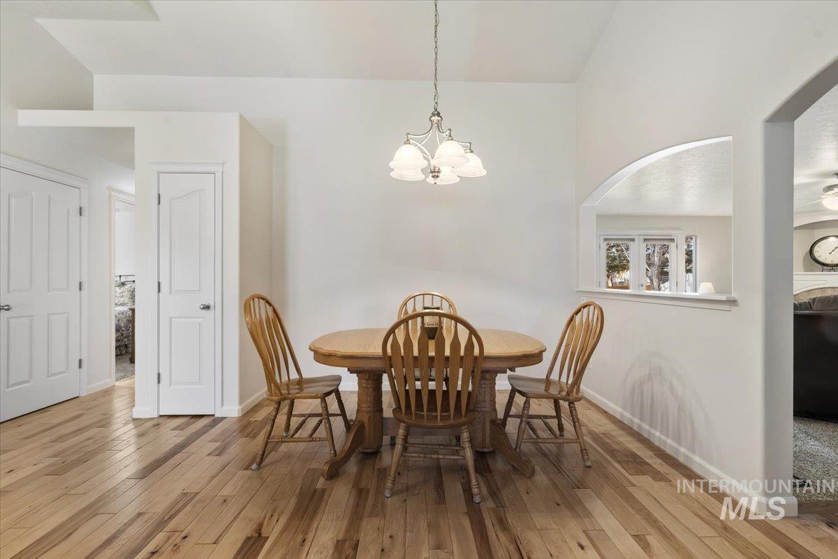 4167 North Arches Way Meridian, ID 83646 - Photo 10 of 36 Dining area with light wood-style flooring, a chandelier, and arched walkways