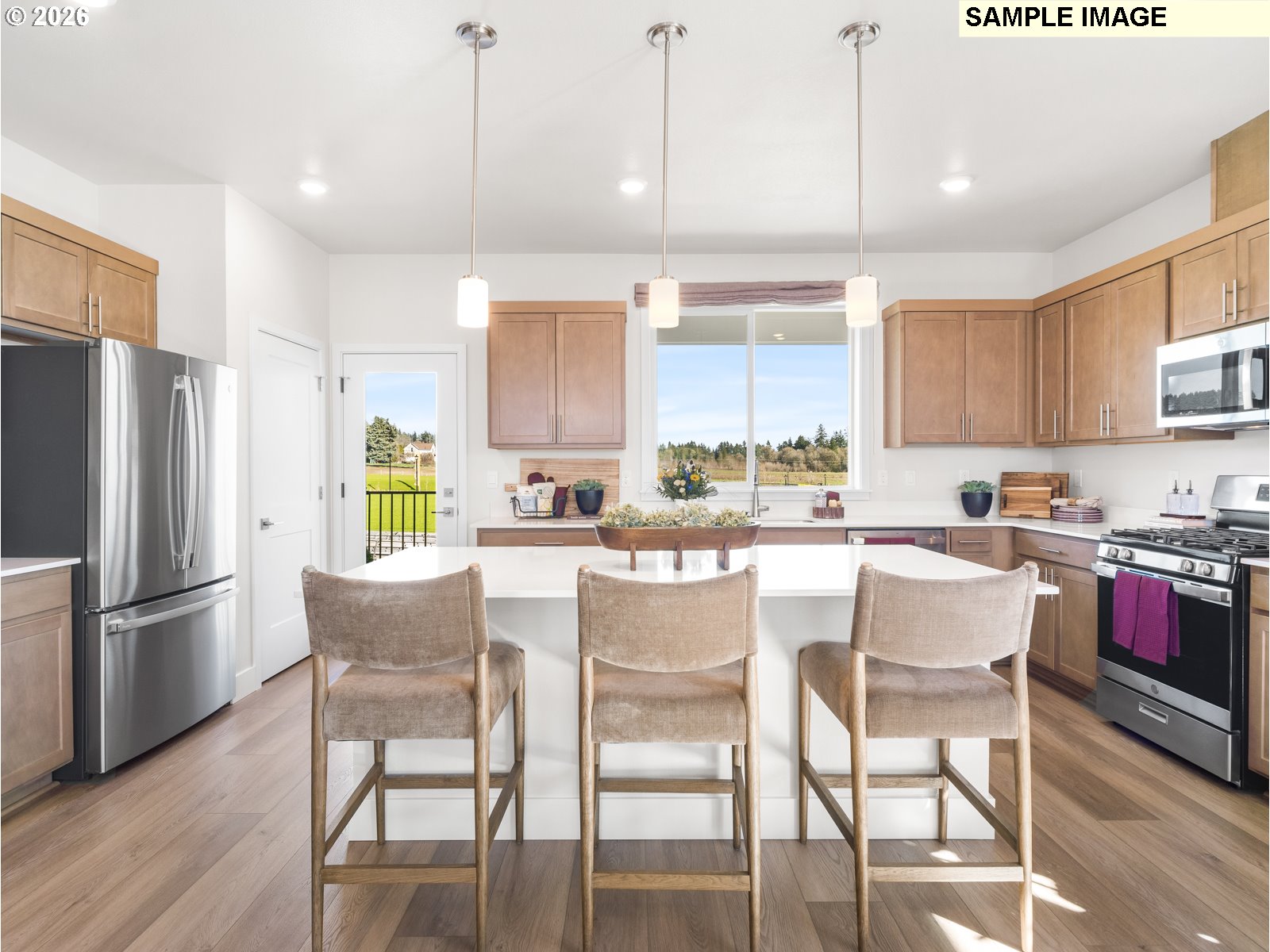 18218 Southwest Tippery Lane Beaverton, OR 97003 - Photo 10 of 21 a kitchen with stainless steel appliances granite countertop a stove a refrigerator a kitchen island with a dining table and chairs