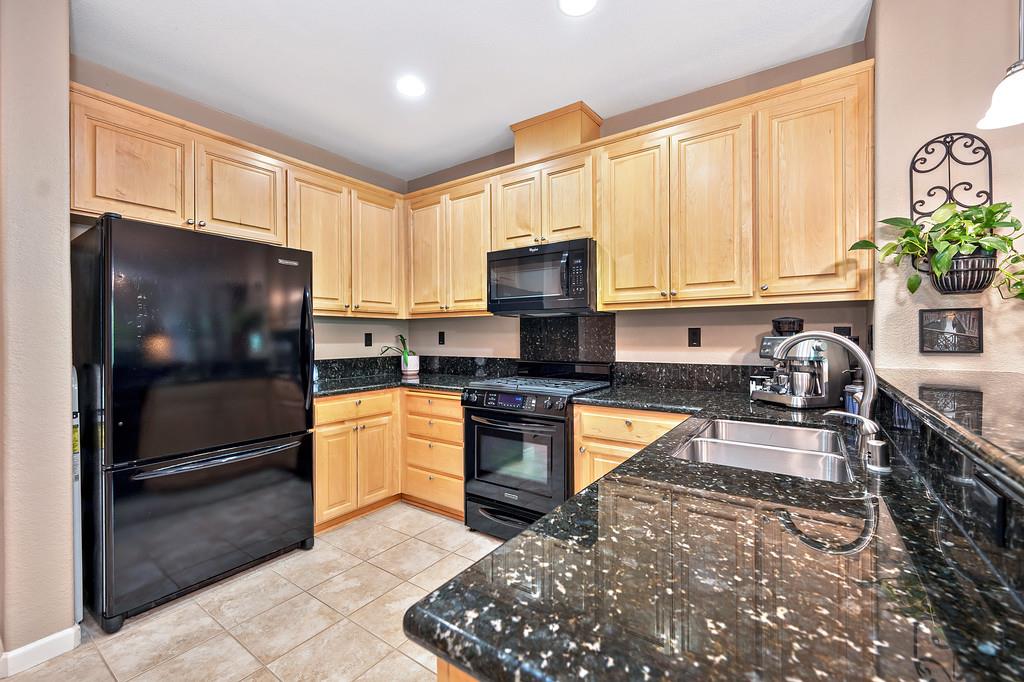 2603 Las Palomas Loop Lincoln, CA 95648 - Photo 11 of 28 a kitchen with granite countertop a refrigerator stove top oven a sink and dishwasher