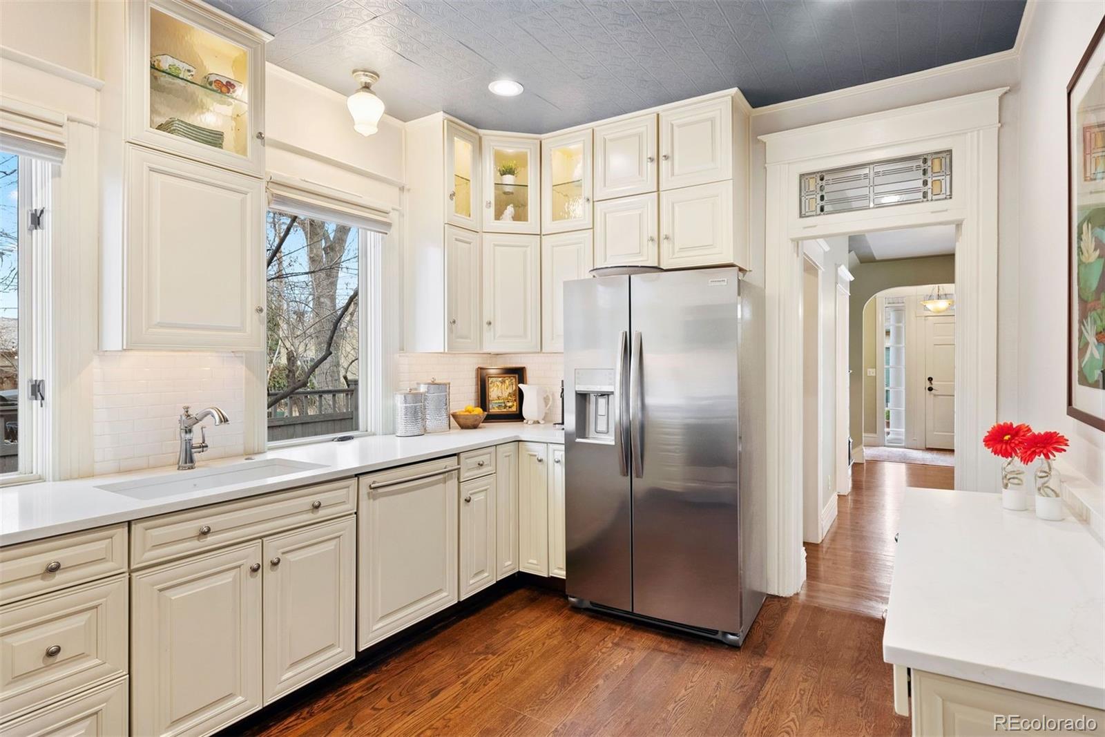 1324 South University Boulevard Denver, CO 80210 - Photo 21 of 47 a kitchen with stainless steel appliances a refrigerator sink and cabinets