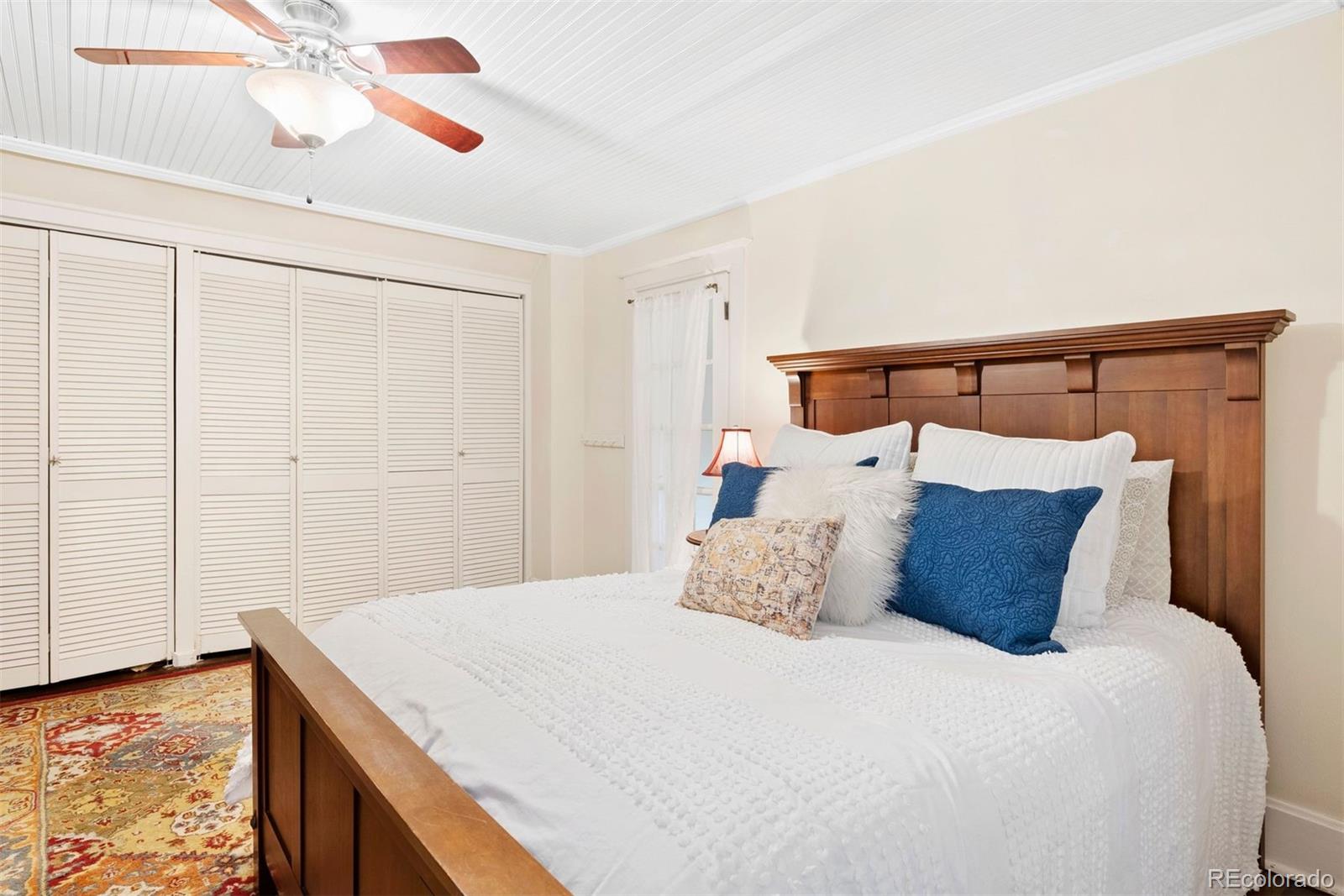 1324 South University Boulevard Denver, CO 80210 - Photo 35 of 47 a bedroom with a bed and a ceiling fan