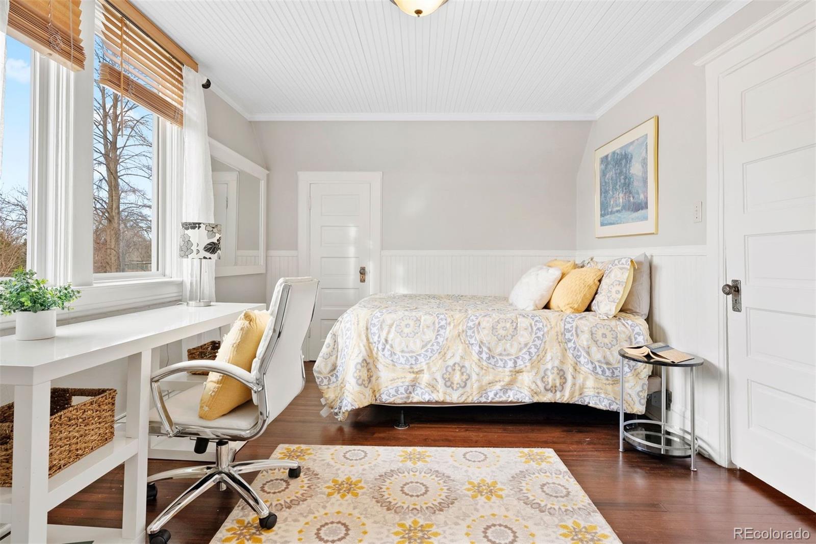 1324 South University Boulevard Denver, CO 80210 - Photo 37 of 47 a bedroom with a bed and wooden floor