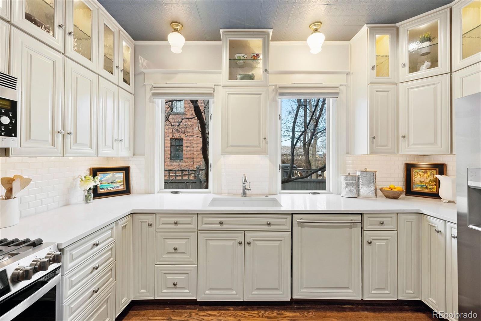 1324 South University Boulevard Denver, CO 80210 - Photo 4 of 47 a kitchen with granite countertop white cabinets and white appliances
