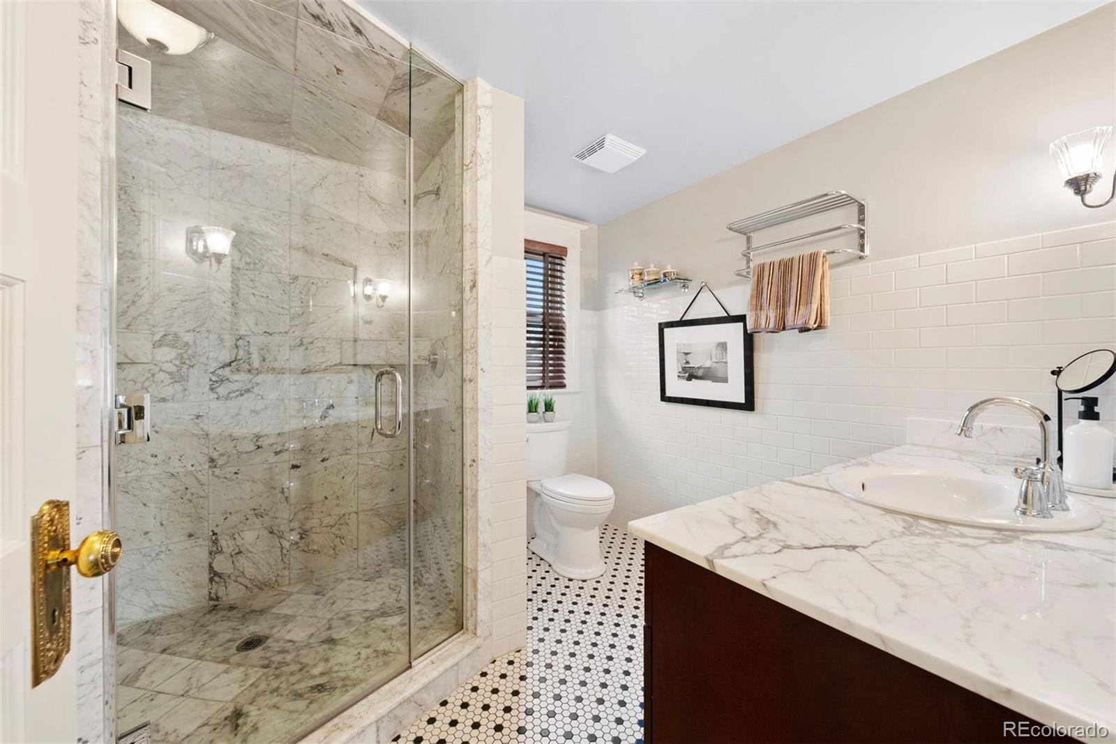 1324 South University Boulevard Denver, CO 80210 - Photo 9 of 47 a bathroom with a sink a toilet and shower