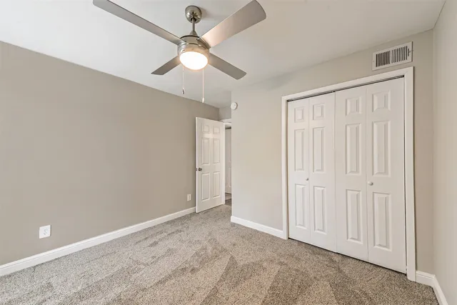 an empty room with fan and windows