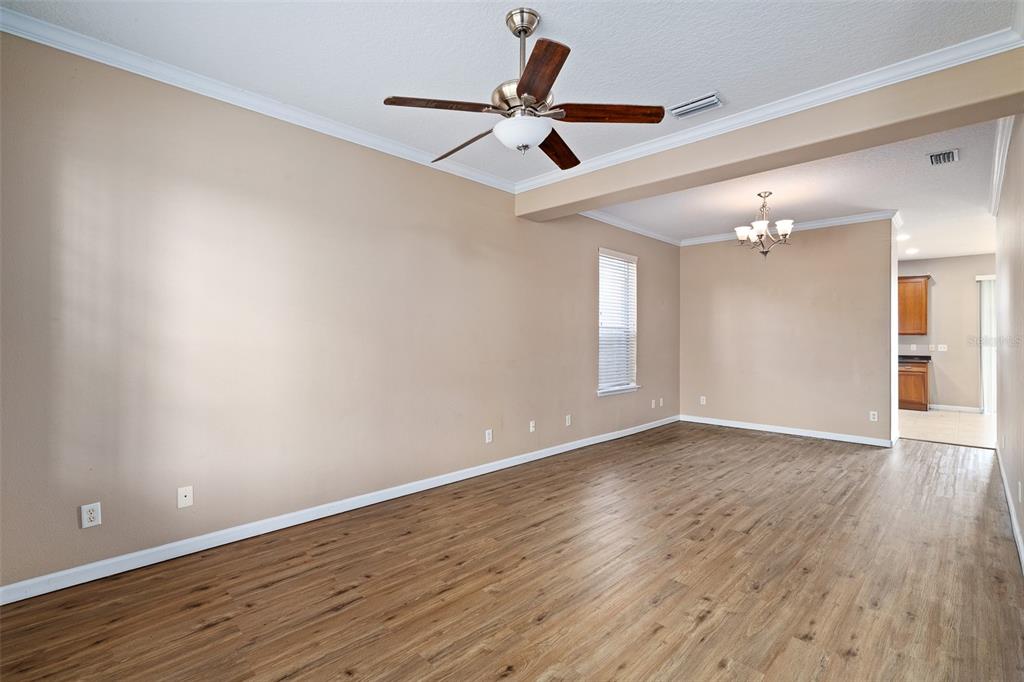 1929 Cove Point Road Port Orange, FL 32128 - Photo 14 of 45 a view of an empty room with wooden floor and a ceiling fan