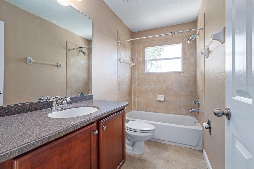 1929 Cove Point Road Port Orange, FL 32128 - Photo 31 of 45 a bathroom with a granite countertop sink toilet and shower