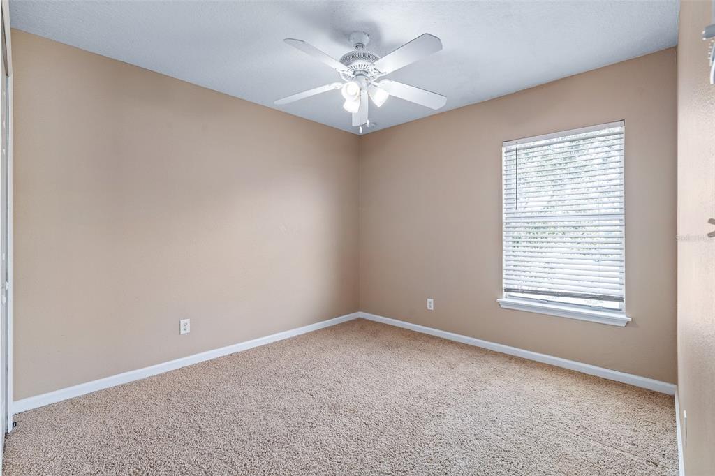 1929 Cove Point Road Port Orange, FL 32128 - Photo 32 of 45 an empty room with a chandelier fan and windows