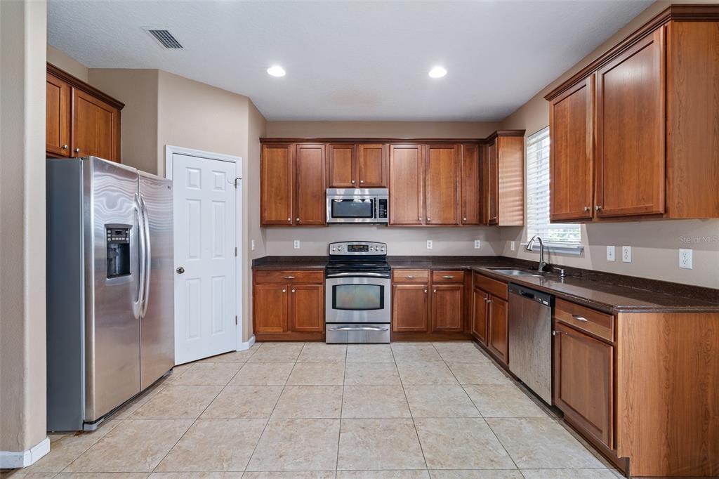 1929 Cove Point Road Port Orange, FL 32128 - Photo 4 of 45 a kitchen with stainless steel appliances granite countertop a refrigerator and a stove top oven