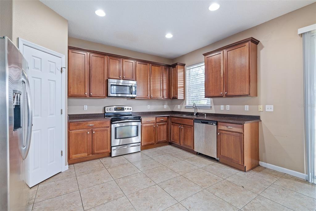 1929 Cove Point Road Port Orange, FL 32128 - Photo 5 of 45 a kitchen with stainless steel appliances granite countertop a stove a sink dishwasher a refrigerator and a microwave oven