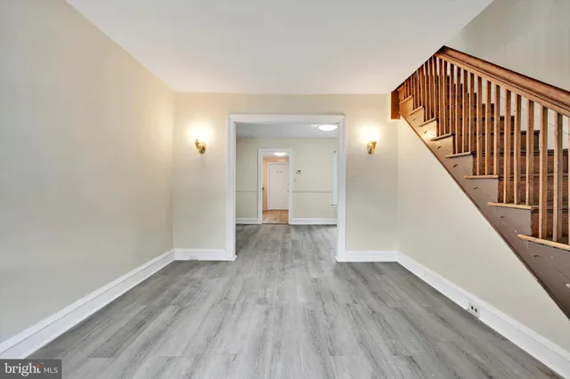 a view of a hallway with wooden floor and staircase