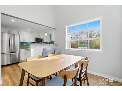 a kitchen with stainless steel appliances a table chairs and refrigerator