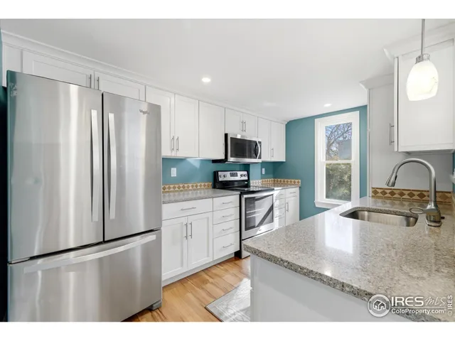 a kitchen with stainless steel appliances granite countertop a refrigerator sink and stove
