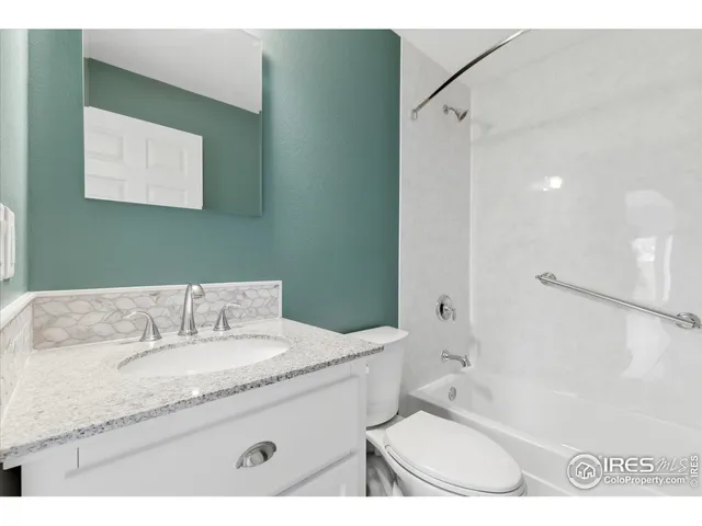 a bathroom with a granite countertop sink a mirror and a bathtub