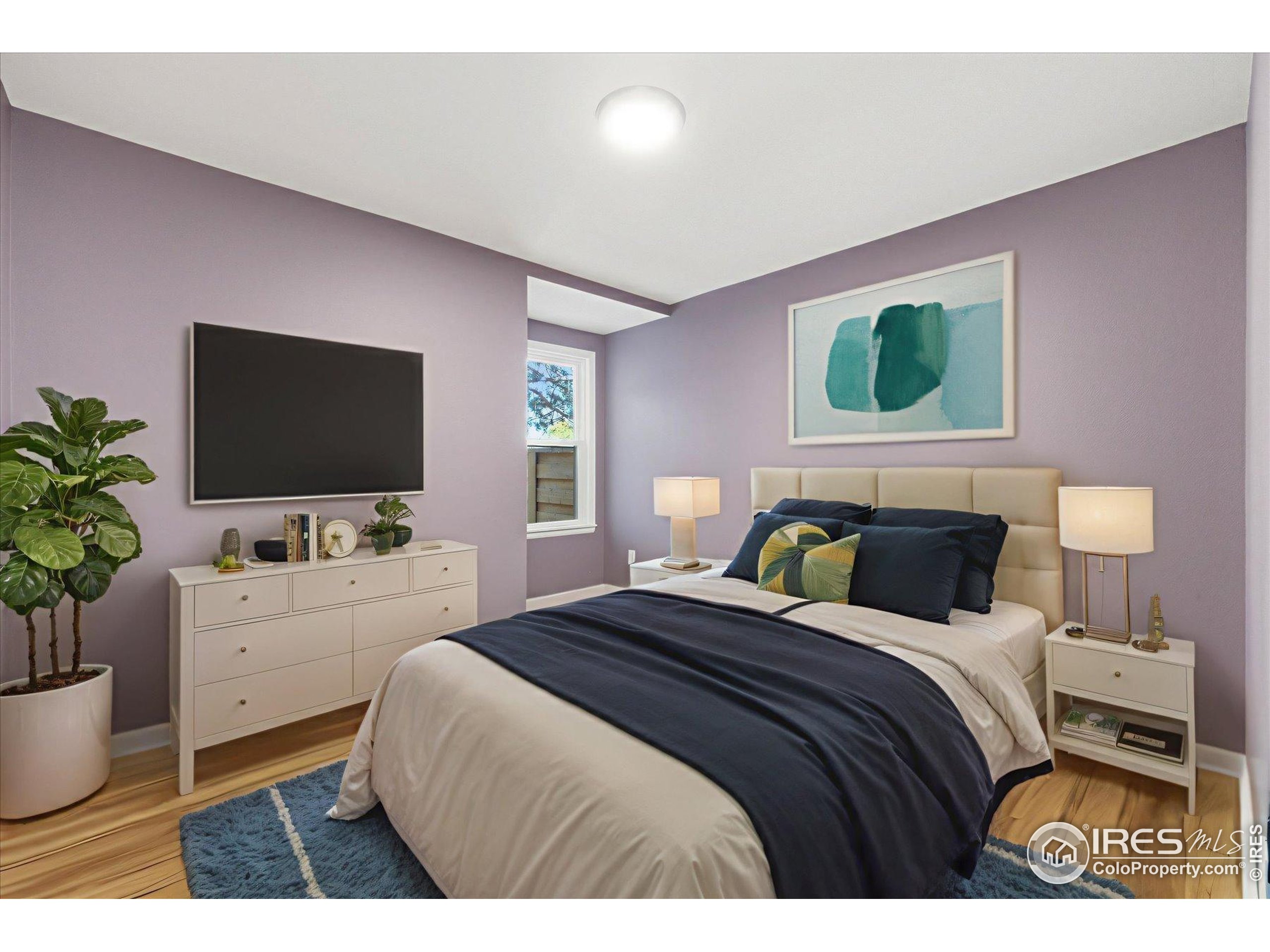 1812 Rice Street Longmont, CO 80501 - Photo 21 of 44 a bedroom with a bed and a flat screen tv