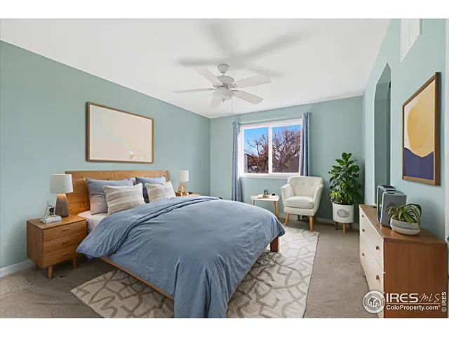 a bedroom with a bed a couch and potted plant