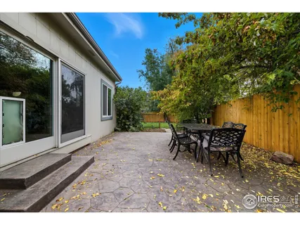 a view of a patio with table and chairs with wooden floor and fence