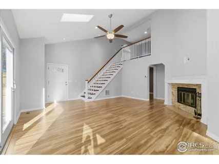 a view of empty room with fireplace and wooden floor