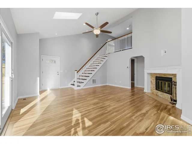 a view of empty room with fireplace and wooden floor