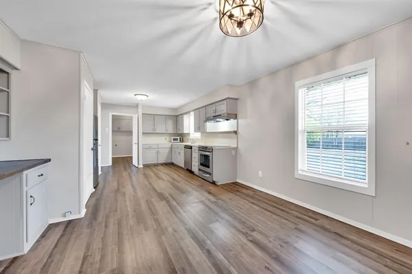 a view of a kitchen with wooden floor and a window