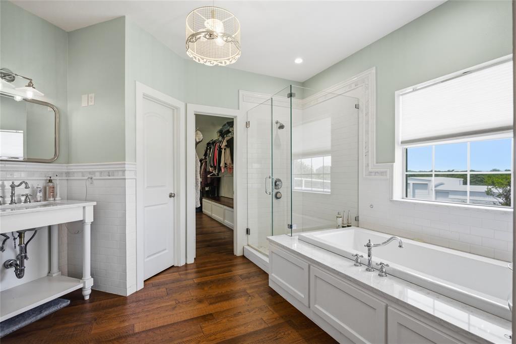 1073 Gordonville Road Gordonville, TX 76245 - Photo 13 of 38 The primary bath features a large square soaking tub with views to the yard, as well as a fun farm-style vanity and large glass shower You can access the closet area through the open door.