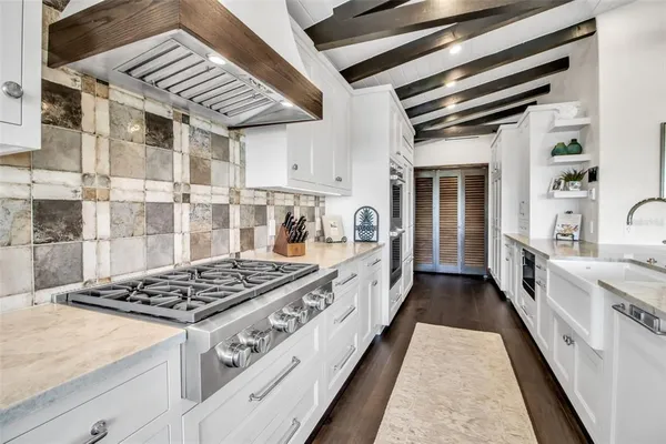 a view of living room kitchen with stainless steel appliances wooden floor and furniture