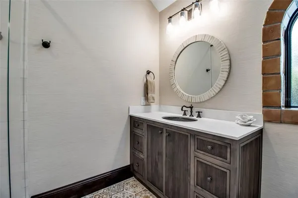 a bathroom with a toilet sink vanity and shower