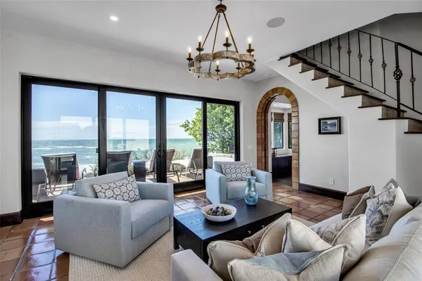 a living room with furniture a chandelier and a large window