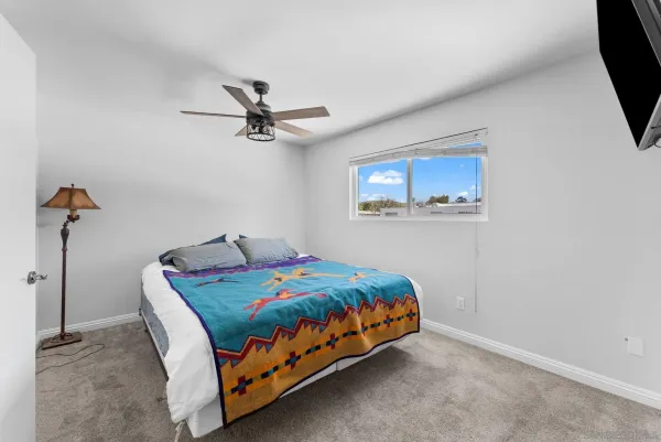 a bedroom with a bed a couch and a chandelier