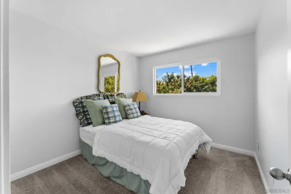 a bedroom with a bed and a painting on the wall