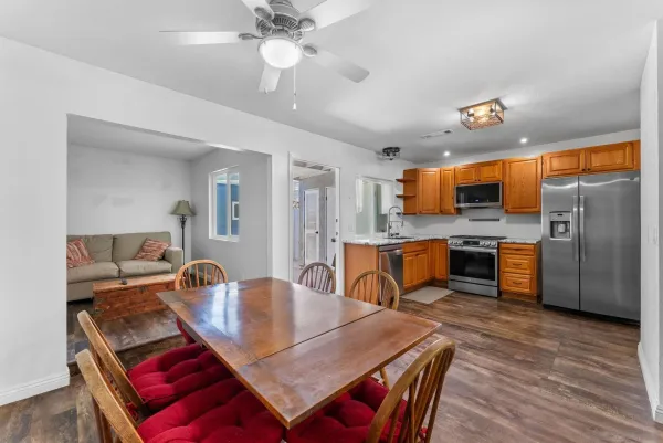 a view of a dining room and livingroom with furniture wooden floor a chandelier