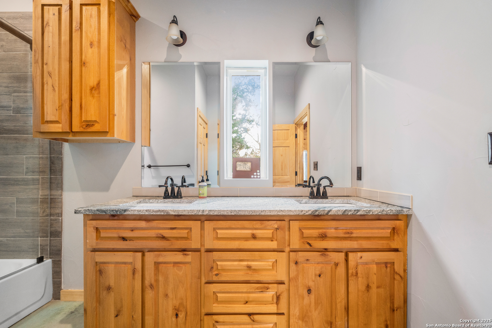 1110 Grandview Circle Bandera, TX 78003 - Photo 16 of 45 a bathroom with a granite countertop sink and a mirror